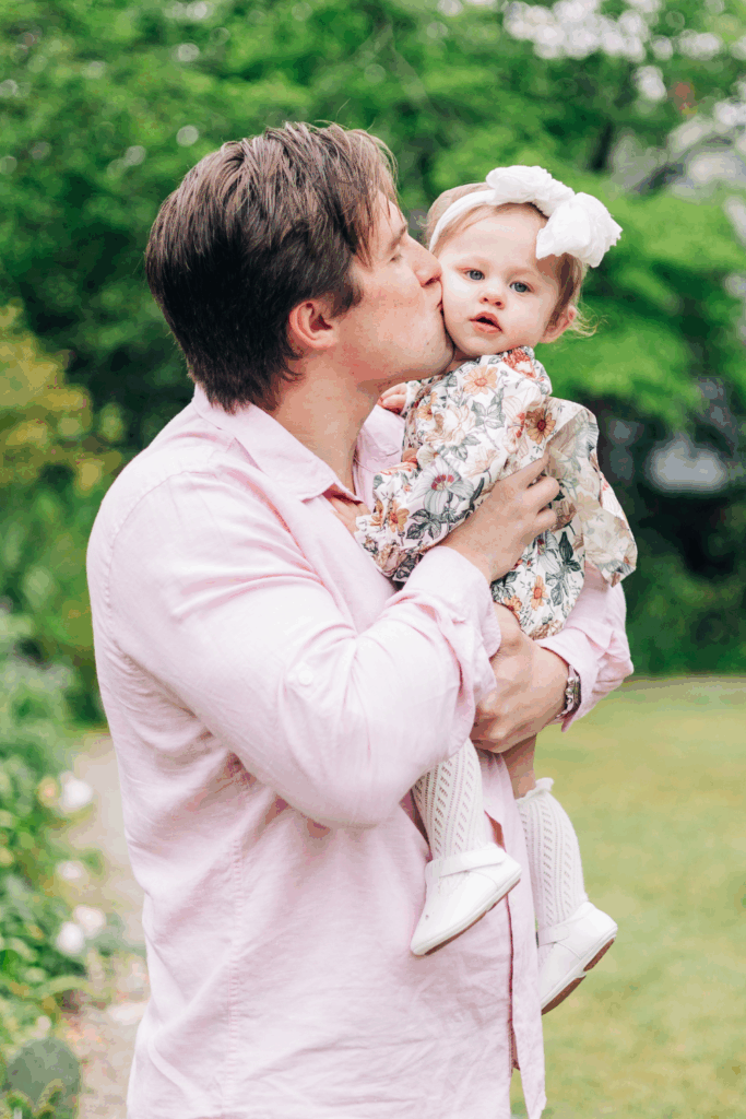 Father kissing their child in muted hone outfits on what to wear for family photos