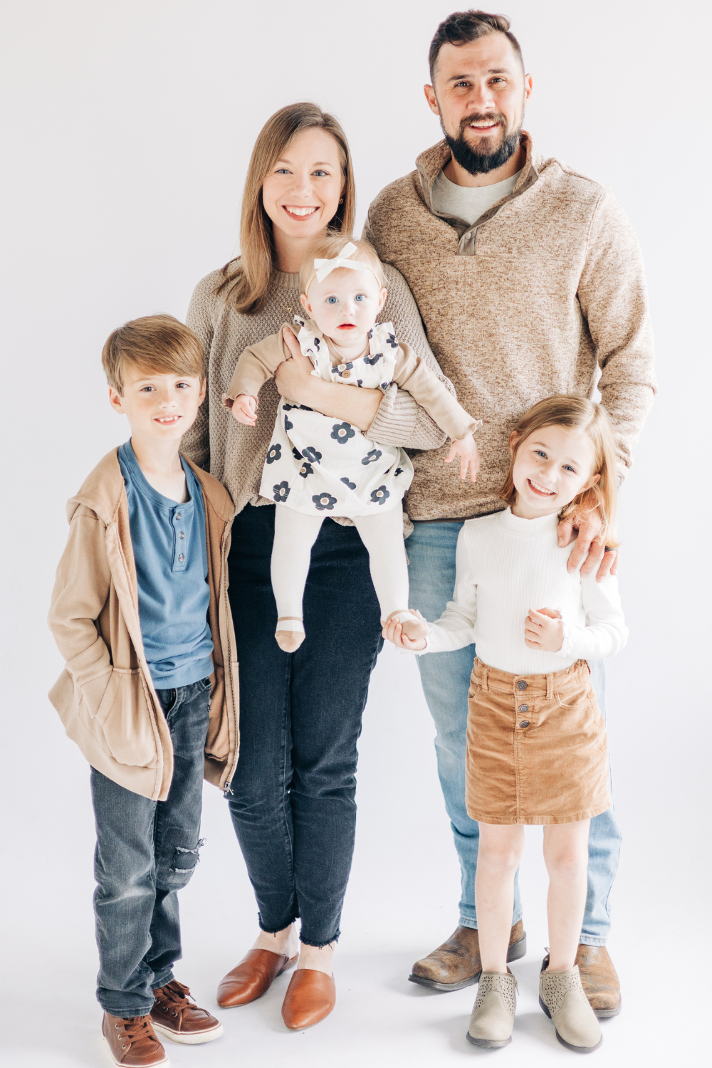 Studio family portrait featuring coordinated neutral outfits and soft textures for what to wear for family photos