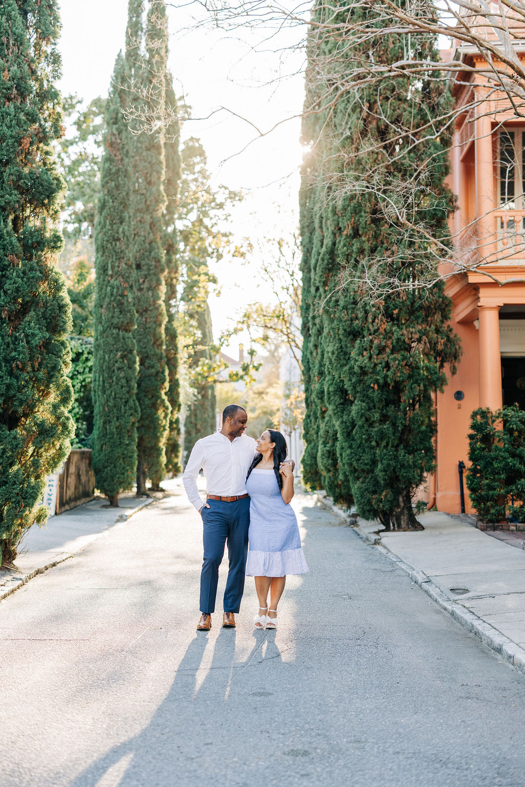 Downtown Charleston engagement photos with pastel buildings and soft evening light