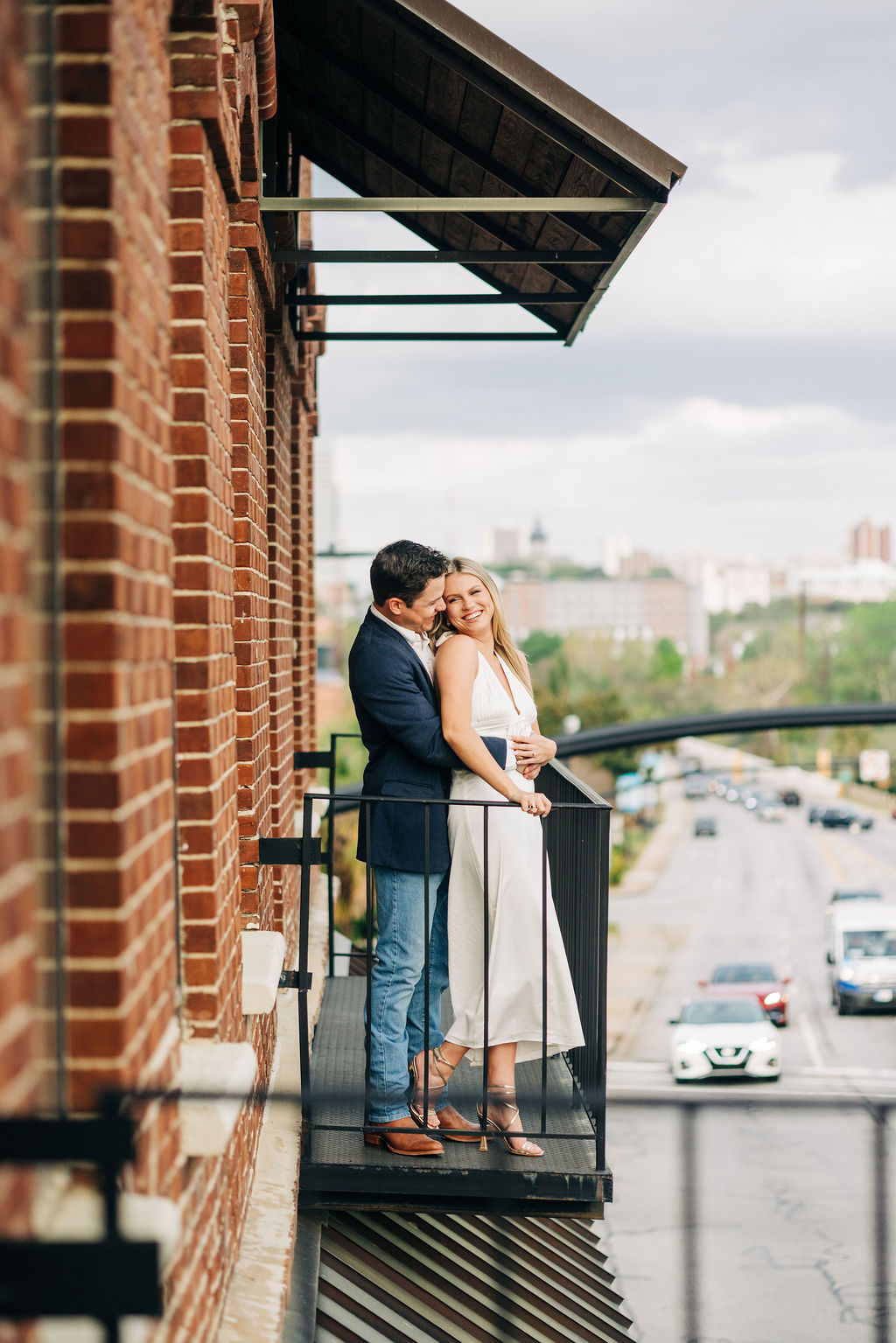 Downtown Columbia engagement photos on a brick balcony overlooking the city streets