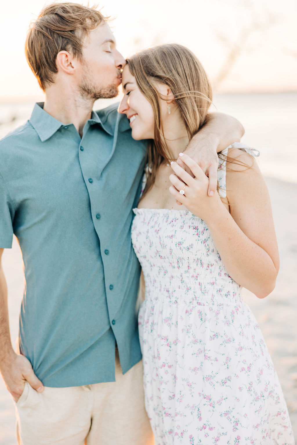 A engaged couple embracing each other on the sands at the beach in South Carolina 